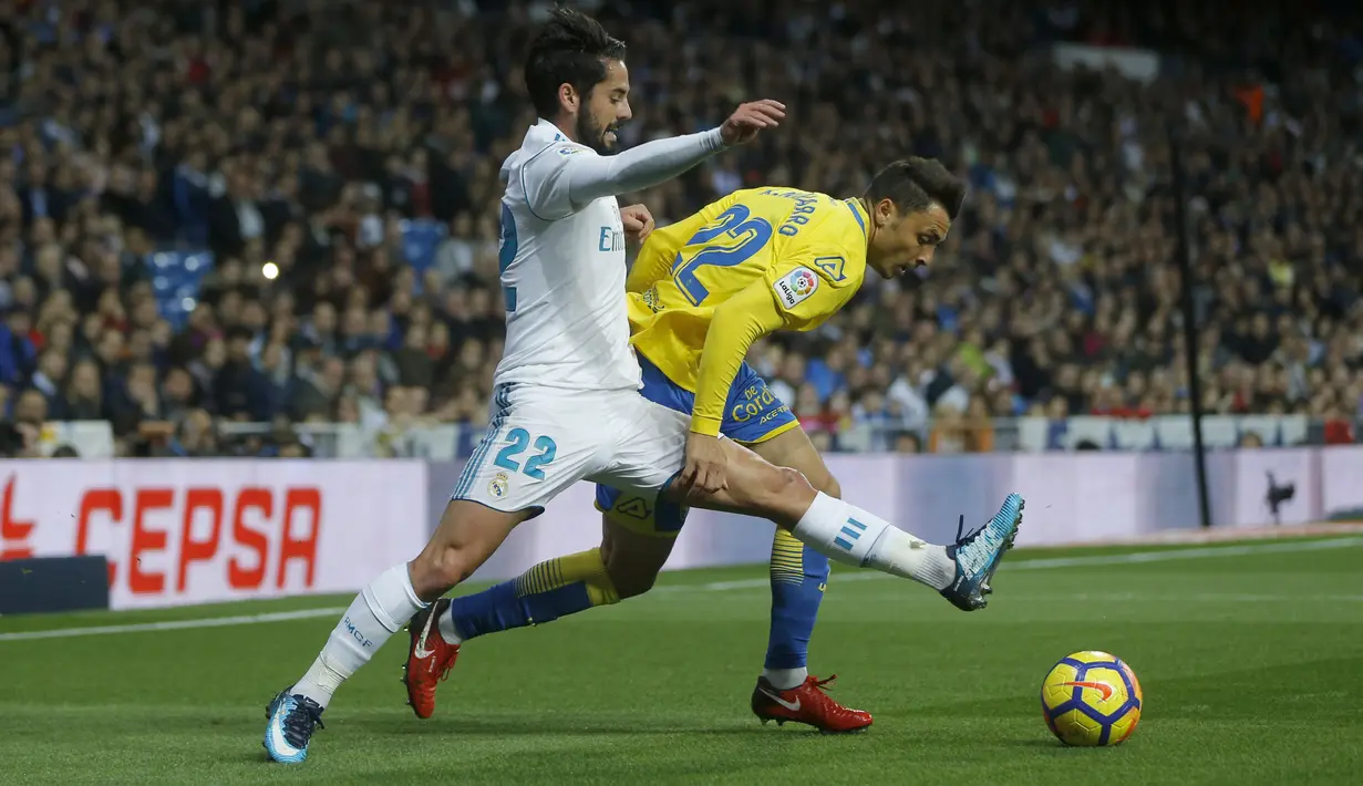 Aksi pemain Real Madrid, Francisco Roman "Isco" (kiri) berebut bola dengan pemain Las Palmas, Joaquin "Ximo" Navarro pada laga La Liga Santander di Santiago Bernabeu stadium, Madrid, (5/11/2017). Real Madrid menang 3-0. (AP/Francisco Seco)