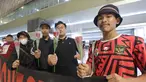 Suporter menunjukkan bunga yang akan diberikan kepada para pemain Timnas Futsal Indonesia yang tiba di Bandara Soekarno-Hatta, Tangerang, Senin (11/11/2024). (Bola.com/M Iqbal Ichsan)