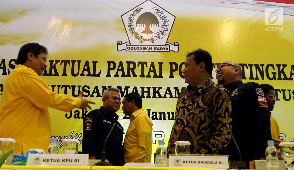 Ketua Umum Partai Golkar Airlangga Hartarto menyerahkan Kartu Anggota Partai Golkar kepada Ketua KPU Arief Budiman saat Verifikasi Faktual Partai Politik Tingkat Pusat Pasca Putusan MK di DPP Golkar, Jakarta, Senin (29/1). (Liputan6.com/JohanTallo)