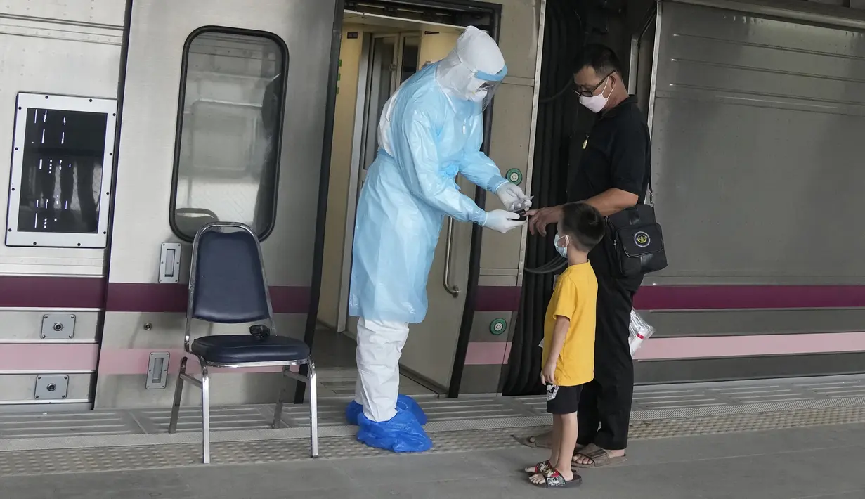 Petugas kesehatan memeriksa kadar oksigen pasien COVID-19 di Stasiun Rangsit, Provinsi Pathum Thani, Thailand, Selasa (27/7/2021). Pengiriman pasien COVID-19 dari Bangkok ke kota asal mereka ini untuk meringankan beban sistem medis ibu kota yang kewalahan. (AP Photo/Sakchai Lalit)