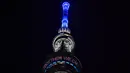 Menara Tokyo Skytree terlihat menyala dengan warna biru bertuliskan "Bersama Kita Semua Bisa Menang" di Tokyo, 5 April 2020. Ungkapan dukungan dan pesan harapan tersebut muncul di tengah merebaknya pandemi virus corona Covid-19. (CHARLY TRIBALLEAU/AFP)