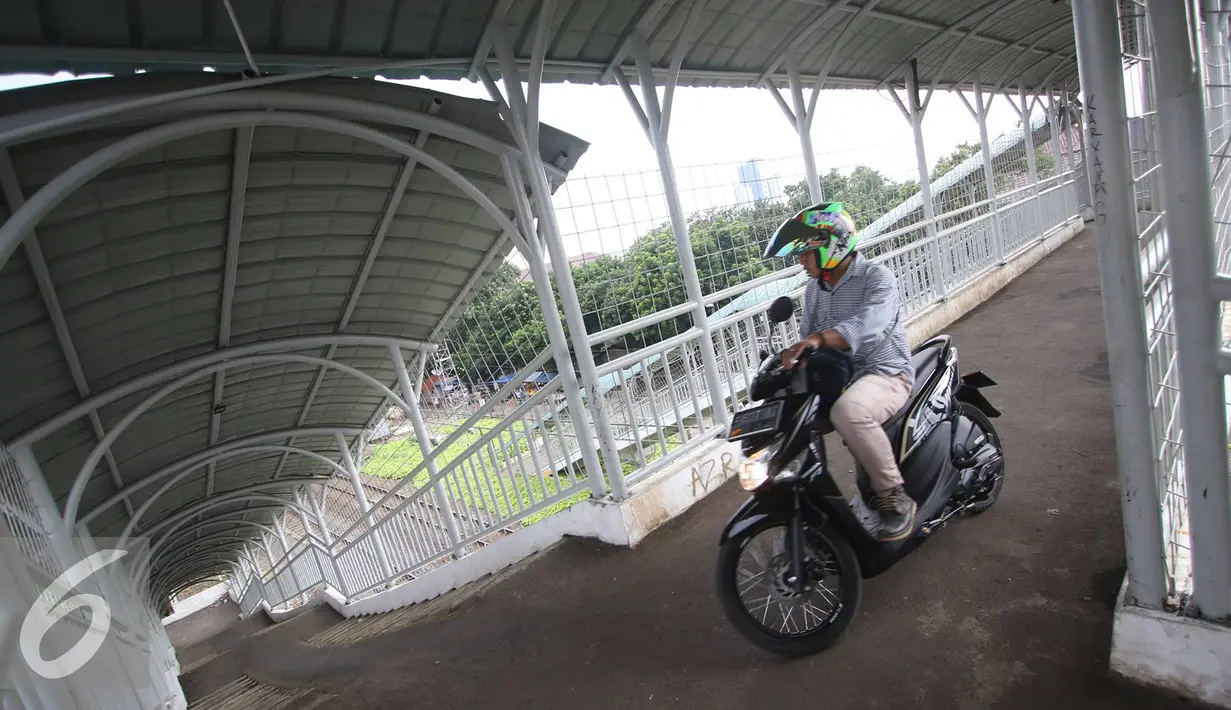 Pengendara motor melintas di jembatan penyeberangan orang (JPO) di kawasan Pasar Minggu, Jakarta, Selasa (6/9). JPO yang seharusnya diperuntukkan bagi pejalan kaki, kini seringkali digunakan pemotor untuk menyeberang. (Liputan6.com/Immanuel Antonius)