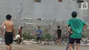 Sejumlah warga bermain sepak bola di antara tumpukan sampah di kawasan Penjaringan, Jakarta, Jumat (1/11/2019). Minimnya lahan bermain di Jakarta membuat warga bermain sepak bola di sekitar tumpukan sampah. (Liputan6.com/Herman Zakharia)
