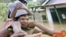 Citizen6, Trenggalek: Seorang bapak menggendong anaknya untuk mengungsi dari banjir yang semakin meninggi.