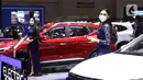 Sales Promotion Girl (SPG) berdiri di samping kendaraan pada Gaikindo Indonesia International Auto Show (GIIAS) 2021 di ICE BSD, Tangerang, Senin (15/11/2021). Kehadiran model menghiasi pameran otomotif GIIAS 2021 yang berlangsung hingga 21 November mendatang. (Liputan6.com/Angga Yuniar)