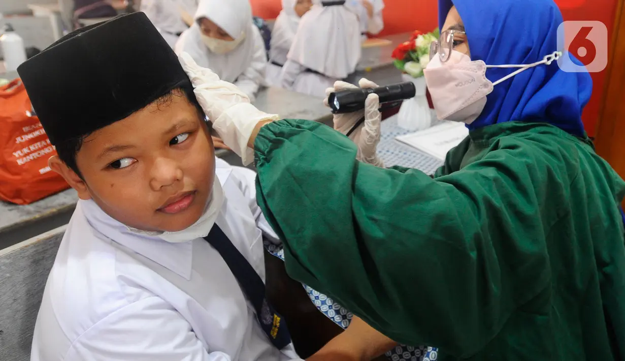 Paramedis Puskesmas Cinere memeriksa kesehatan telinga murid kelas III di SDI Al Hidayah, Cinere, depok, Senin (12/9/20222). Selain pemeriksaan gigi, telinga, dan kuku yang dilakukan periodik 6 bulan sekali  juga dilakukan penyuluhan kesehatan dan pemberian obat cacing kepada anak-anak.
(merdeka.com/Arie Basuki)