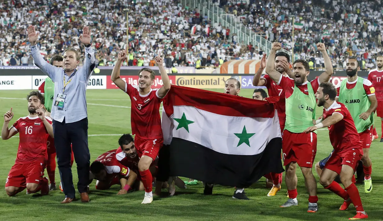 Para pemain Suriah berpesta usai menahan imbang Iran 2-2 pada laga kualifikasi Piala Dunia 2018 di Stadion Azadi, Taheran, Selasa (5/9/2017). Finis urutan tiga grup A, Suriah lolos ke babak playoff untuk menantang Australia. (AFP/Atta Kenare)
