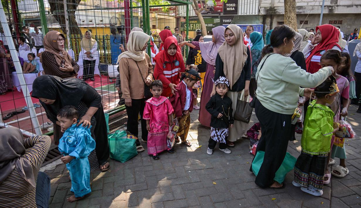 Pemberian vaksin Campak-Rubella sangat efektif melindungi anak dari komplikasi serius seperti pneumonia, infeksi otak, dan cacat lahir (sindrom rubella kongenital). Tampak dalam foto, para ibu dan anak-anak mereka menunggu giliran untuk menerima vaksin Campak-Rubella sebagai bagian dari program kesehatan pemerintah untuk memerangi penyakit anak di Surabaya, Jawa Timur pada Rabu 6 Mei 2026. (JUNI KRISWANTO/AFP)