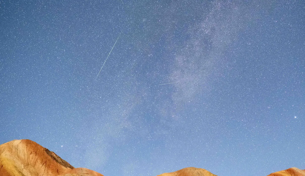 Foto eksposur panjang yang diabadikan pada 13 Agustus 2020 ini menunjukkan hujan meteor Perseid di Taman Geologi Nasional Danxia Zhangye di Zhangye, Provinsi Gansu, China barat laut. (Xinhua/Zhong Xiaoliang)