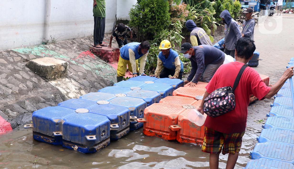 Petugas membuat jembatan apung saat banjir melanda Perumahan Periuk Damai, Tangerang, Banten, Selasa (23/2/2021). Adanya jembatan apung mempermudah warga saat melintasi banjir setinggi 2,5 meter di tempat tersebut. (Liputan6.com/Angga Yuniar)