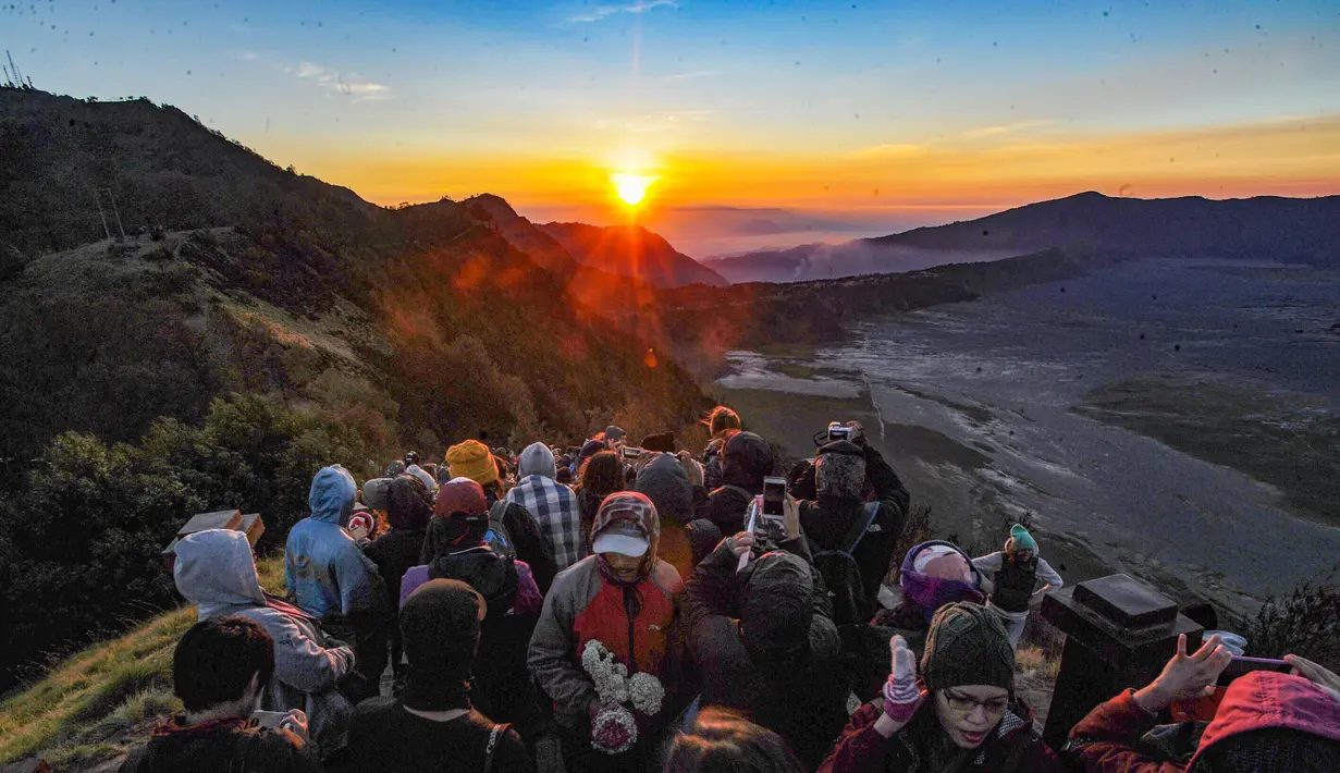 Pengunjung memadati Love Hill menunggu matari terbit di Bromo, Jawa Timur. Gunung Bromo dikenal sebagai salah satu lanskap paling magis di Indonesia. Perpaduan antara gunung megah, lautan pasir luas, serta kabut tipis yang menari di pagi hari menciptakan panorama emas yang sulit ditandingi. (merdeka.com/Arie Basuki)