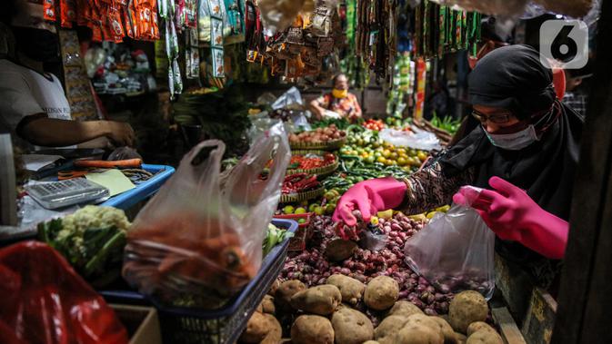Aktivitas pedagang dan konsumen di Pasar Tradisonal Cempaka Putih, Jakarta, Kamis (11/6/2020). Pengelola pasar tradisional diwajibkan melaksanakan protokol kesehatan salah satunya dengan pembatasan jumlah konsumen hanya 50 persen kapasitas. (Liputan6.com/Faizal Fanani)