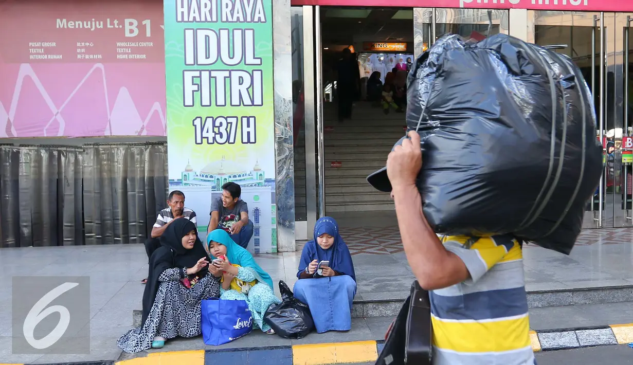 Pengunjung beristirahat di depan pintu masuk Blok B Pasar Tanah Abang, Jakarta, Jumat (15/7). Libur Lebaran telah selesai, namun kawasan Blok B Pasar Tanah Abang masih sepi. (Liputan6.com/Angga Yuniar)