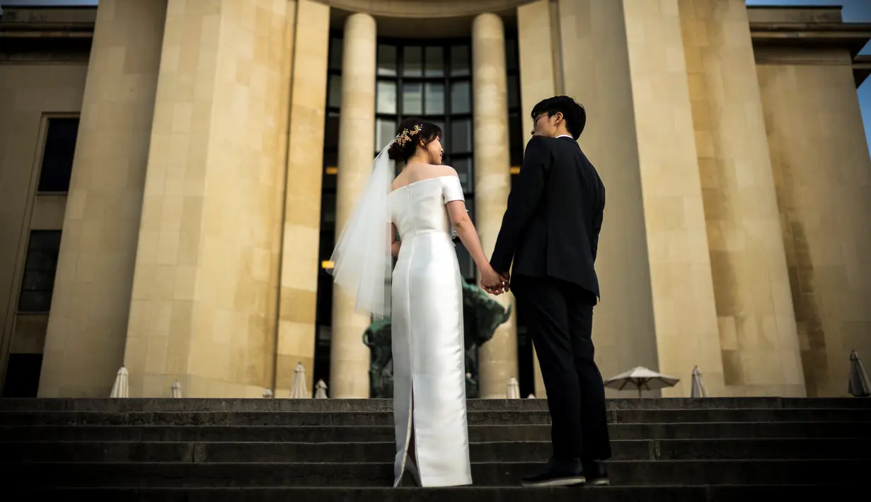 Sepasang calon pengantin berpose ketika melakukan foto prewedding di alun-alun Trocadero di Paris, 4 Juli 2017. Trocadero ini tepat terletak antara Menara Eiffel dan Sungai Seine. (AFP PHOTO / LIONEL BONAVENTURE)