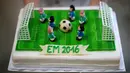 Seseorang menunjukkan salah satu kue bertema Euro 2016 yang dibuat di sebuah tempat pembuatan kue di Munich, Jerman, Senin (20/6). Beraneka kue bertema Euro 2016 mewarnai perhelatan sepakbola Eropa. (REUTERS/Michaela Rehle)