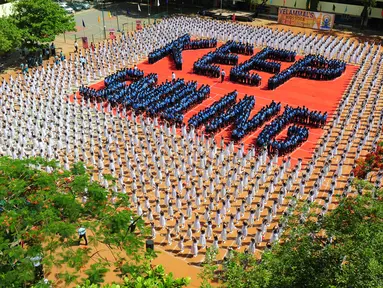 Ribuan pelajar India membentuk formasi saat melakukan senam yoga di Chennai, India, Senin (20/6). Kegiatan ini untuk memeriahkan perayaan Hari Yoga Internasional. (AFP PHOTO/ Arun Sankar)