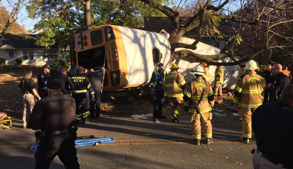 Tim penyelamat berkumpul di dekat bus sekolah yang rusak setelah menabrak sebuah rumah di Chattanooga, Tennessee, Senin (21/11). Bus itu membawa sekitar 35 anak dari usia TK hingga kelas 5 sekolah dasar. (Courtesy of Chattanooga Fire Dept/via REUTERS)