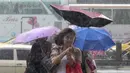 Warga memegang payung sambil berjalan menghindari angin kencang yang disebabkan topan Dujuan di Taipei, Taiwan, Senin (28/9). Ribuan orang diungsikan untuk menghadapi topan raksasa Dujuan yang diprediksikan akan menyerang Taiwan. (REUTERS/Pichi Chuang)