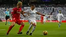Pemain Real Madrid, Lucas Vazquez berebut bola dengan pemain Sevilla, Simon Kjaer pada lanjutan pekan ke-15 Liga Spanyol di Santiago Bernabeu, Sabtu (9/12). Bermain di depan pendukungnya sendiri, Real Madrid menang telak 5-0. (AP/Francisco Seco)