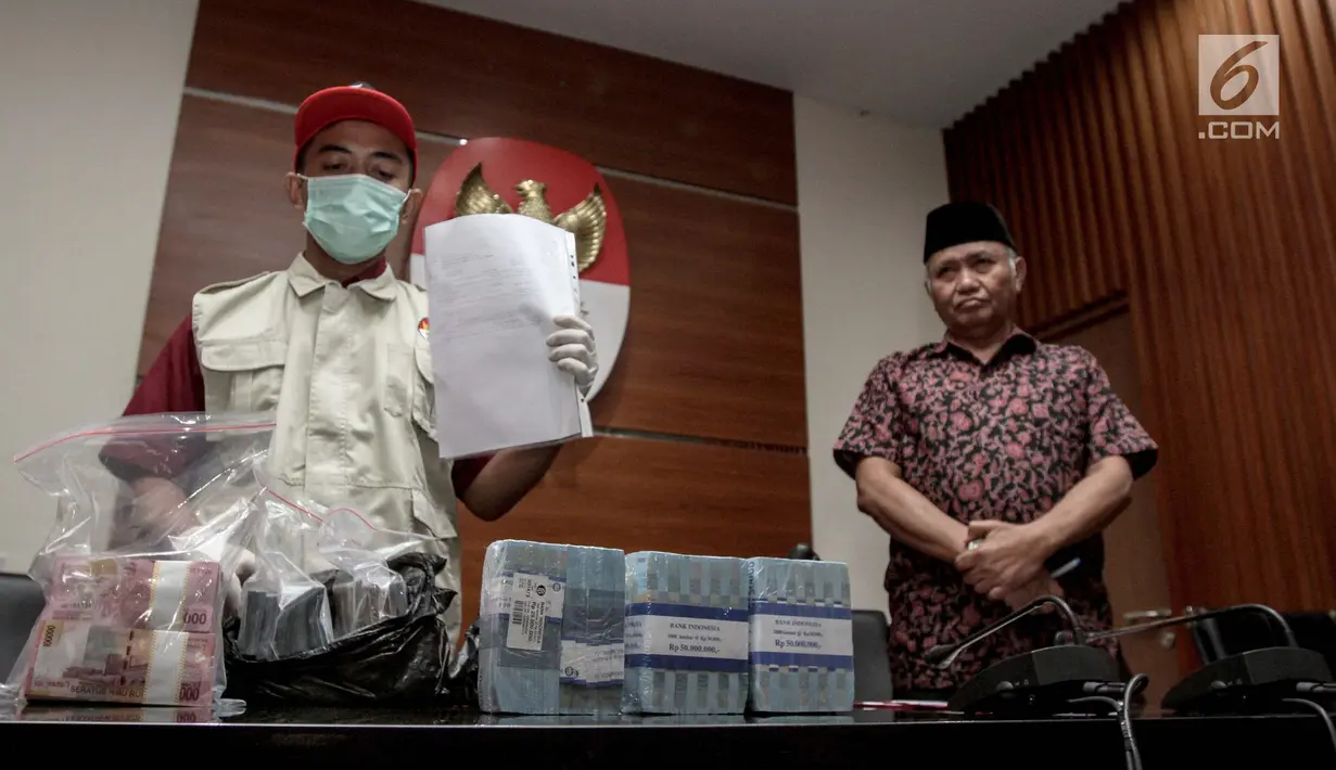 Petugas bersama Ketua KPK Agus Rahardjo (kanan) menunjukkan barang bukti hasil operasi tangkap tangan (OTT) di gedung KPK, Jakarta, Jumat (5/1). (Liputan6.com/Faizal Fanani)