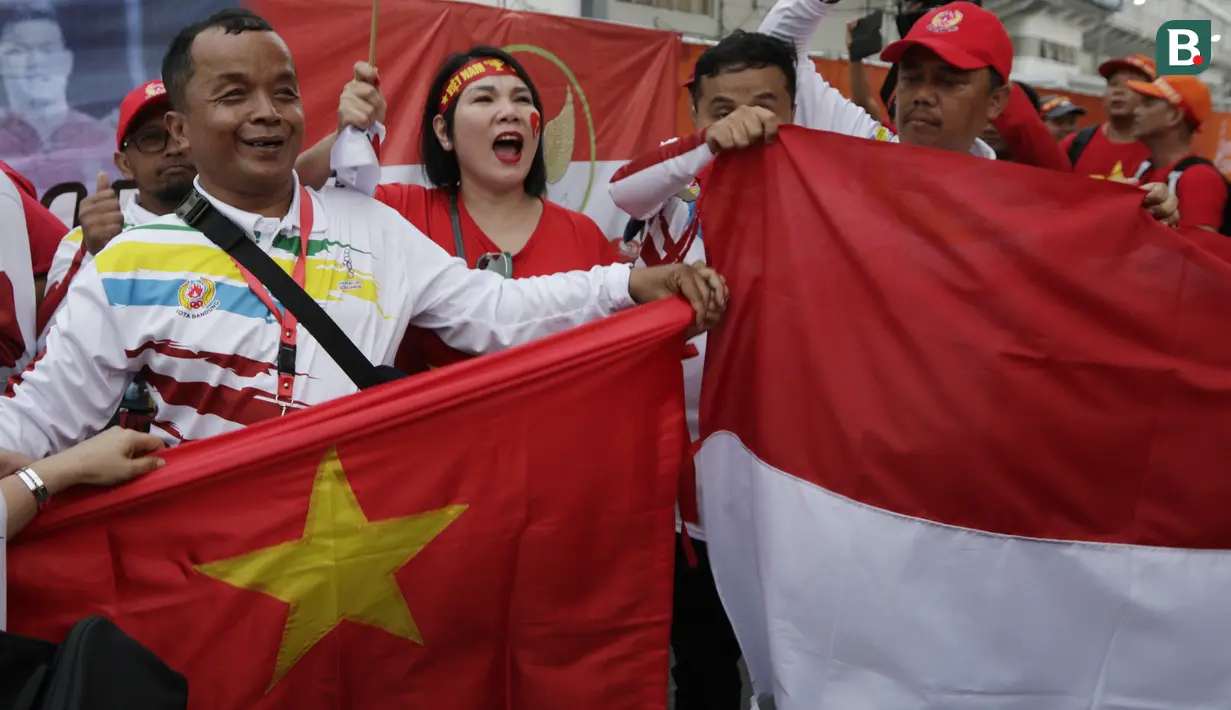 Suporter Timnas Indonesia U-22 dan Vietnam U-22 bernyanyi bersama jelang laga final SEA Games 2019 di Stadion Rizal Memorial, Manila, Selasa (10/12). Meski bersaing para suporter tetap akrab. (Bola.com/M Iqbal Ichsan)
