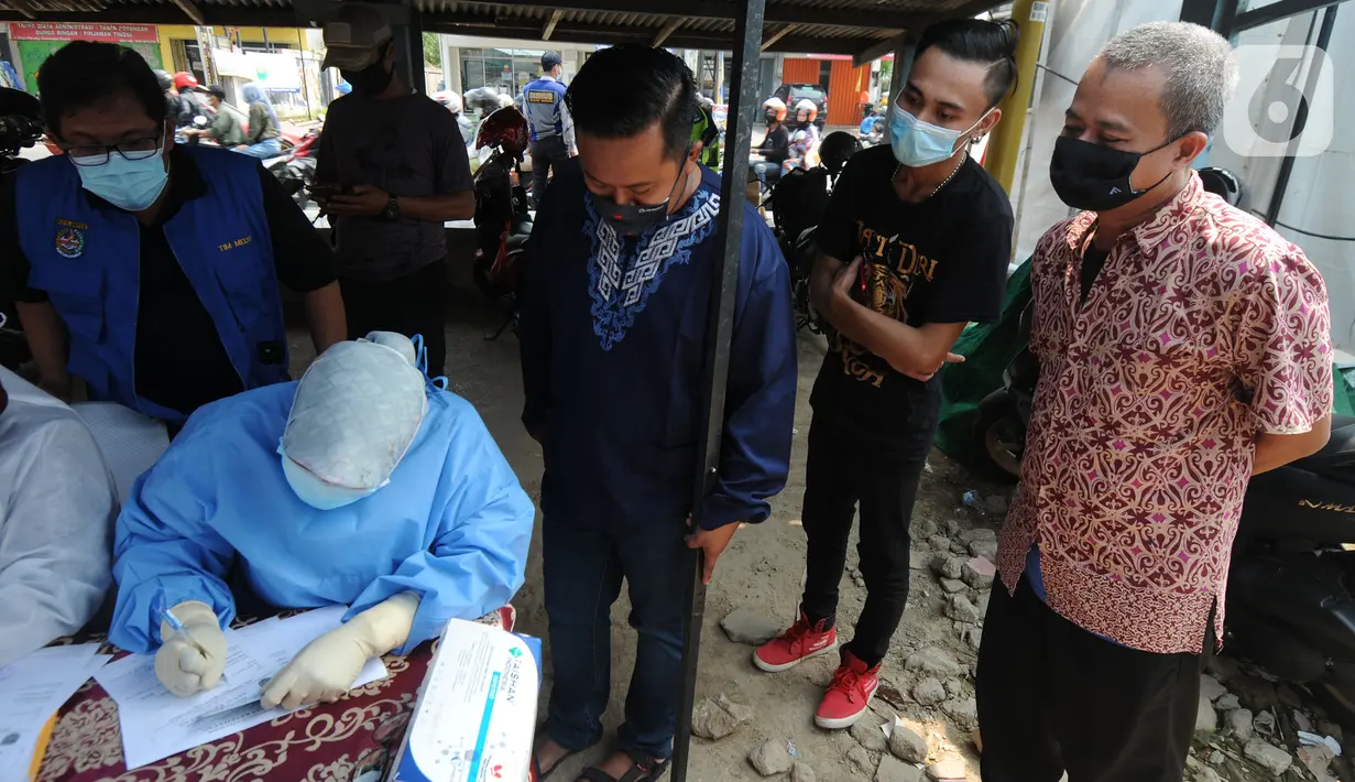 Paramedis mendata pemudik saat pelaksanaan swab antigen di perbatasan Depok-Bogor, Jalan Raya Parung-Ciputat, Depok, Jawa Barat, Minggu (16/5/2021). Swab antigen untuk para pemudik ini akan berlangsung tujuh hari ke depan. (merdeka.com/Arie Basuki)