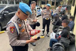 Polisi mengevakuasi pemudik yang mengalami kecelakaan tunggal diduga akibat mabuk saat mengendarai sepeda motor di Jalan Sudirman, Garut, Jawa Barat. (Foto: Antara)