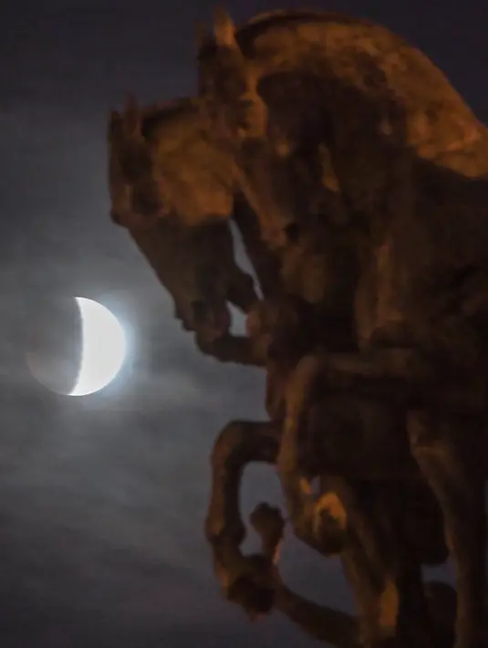 Fenomena gerhana bulan sebagian (parsial) terlihat dari belakang Monumen Kemerdekaan di Sao Paulo, Brasil pada Selasa (16/7/2019). Gerhana bulan parsial ini bisa diamati dari Amerika Selatan, Eropa, Afrika, Asia dan Australia. (NELSON ALMEIDA/AFP)