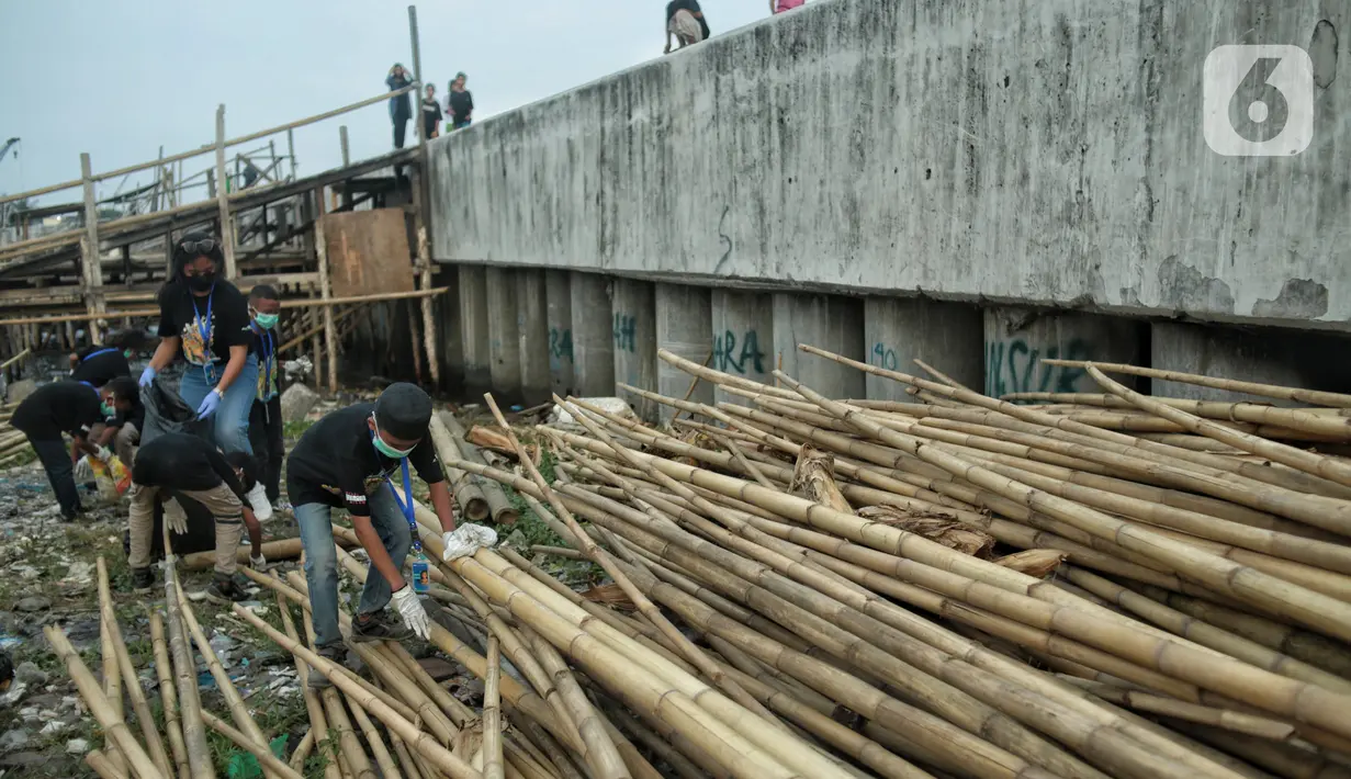 Anak-anak pesisir dan sukarelawan saat membersihkan sampah di Pemukiman Nelayan Manunggal, Cilincing, Jakarta Utara, Minggu (18/9/2022). Tumpukan sampah yang berserakan di kawasan pemukiman nelayan Manunggal, Cilincing menginisasi Kelas Jurnalis Cilik untuk membersihkan sampah dan mengedukasi kepada anak-anak pesisir serta masyarakat pentingnya menjaga kebersihan di lingkungan sekitar. (merdeka.com/Iqbal S. Nugroho)