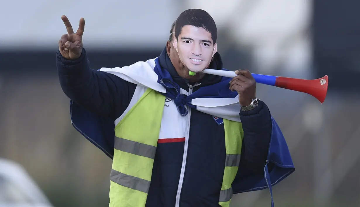 Seorang fans mengenakan topeng Luis Suarez saat sang pemain menghadiri upacara penyambutan sebagai pemain baru Nacional di Stadion Gran Parque Central, di Montevideo, pada 31 Juli, 2022. Luis Suarez kembali ke Uruguay untuk bergabung dengan Nacional, klub tempat ia memulai karirnya 17 tahun lalu sebagai salah satu striker terbaik di generasinya. (AFP/Pablo Porciuncula)