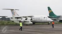 Petugas berjalan di depan pesawat terbang yang terparkir di Bandara Pondok Cabe, Tangsel, Senin (22/2). Maret mendatang, maskapai Garuda Indonesia akan membuka penerbangan dari bandara milik PT Pertamina (persero) ini. (Liputan6.com/Immanuel Antonius)
