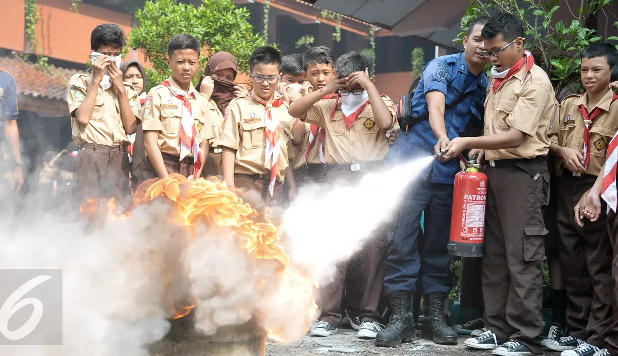 Petugas mengajarkan cara menggunakan Alat Pemadam Api Ringan (Apar) kepada murid SMPN 43 Mampang Prapatan, Jakarta, Rabu (14/9). Dinas Pemadam Kebakaran (Damkar) menggelar pelatihan singkat mengatasi kebakaran untuk siswa SMP. (Liputan6.com/Yoppy Renato)