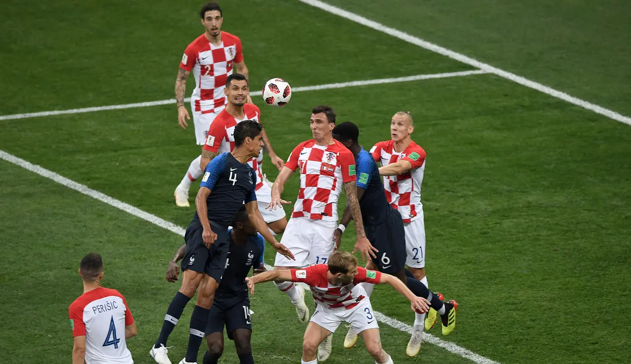 Pemain depan Kroasia Mario Mandzukic (tengah) menyundul bola dan mencetak gol bunuh diri setelah tendangan bebas pemain Prancis Antoine Griezmann pada pertandingan final Piala Dunia 2018 di Stadion Luzhniki Moskow, (15/7). (AFP PHOTO / Gabriel Bouys)