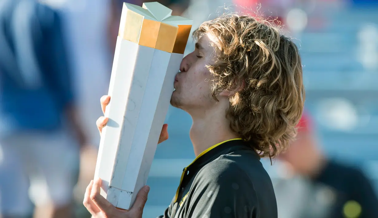 Petenis Jerman, Alexander Zverev mencium trofi usai meraih gelar juara Piala Rogers 2017 di Montreal, Minggu (13/8). Zverev menjadi petenis Jerman pertama sejak 1987 yang mampu juara di Rogers Cup kategori putra. (Paul Chiasson/The Canadian Press via AP)