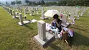Warga Korea Selatan,Oh Myung-Soon menangis di depan batu nisan saudaranya yang meninggal selama Perang Korea di pemakaman nasional, Seoul, Korea Selatan, Rabu (6/6). Kegiatan ini dilakukan dalam Memorial Day. (AP Photo/Ahn Young-joon)