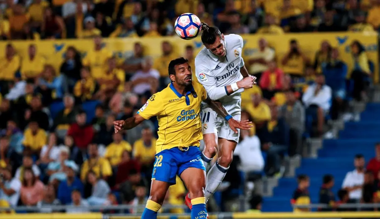 Pemain Real Madrid, Gareth Bale, duel dengan pemain Las Palmas, Michel Macedo, dalam lanjutan La Liga di Gran Canaria, Las Palmas, Minggu (25/9/2016) dini hari WIB. (Reuters/Juan Medina)