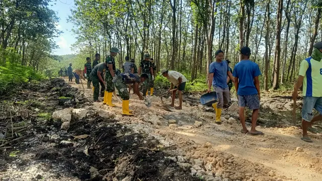 Anggota TNI dari Kodim 0721/Blora saat berjibaku bersama masyarakat dalam kegiatan TMMD ke-113 membangun jalan hutan menuju Dukuh Alas Malang, Desa Pengkoljagong, Kecamatan Jati, Kabupaten Blora. (Liputan6.com/Ahmad Adirin)