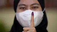 Seorang perempuan menunjukkan jarinya yang bertinta setelah memberikan suara selama pemilihan umum (pemilu) di Seberang Perai, negara bagian Penang, Malaysia, Sabtu (19/11/2022). Pemilu ini sekaligus menentukan perdana menteri (PM) yang baru. (AP Photo/Vincent Thian)