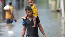 Warga Sri Lanka melewati banjir yang menerjang kawasan mereka di Kaduwela, Kolombo, Sabtu (21/5/2016). Dikabarkan sekitar 80 orang tewas akibat hujan dan tanah longsor yang melanda Sri Lanka. (AFP Photo/Ishara S Kodikara)