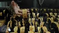 Pedagang menunjukan perhiasan emas di sebuah toko Kawasan Cikini, Jakarta, Kamis (3/9/2015). Harga emas milik PT Aneka Tambang Tbk (Antam) hari ini terpantau bergerak stabil di posisi Rp560 ribu per gram. (Liputan6.com/Johan Tallo)