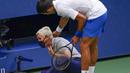 Petenis Serbia, Novak Djokovic, menghampiri hakim garis yang terkena bola pada AS Terbuka di Flushing Meadows, Senin (7/9/2020). Djokovic didiskualifikasi karena memukulkan bola tenis ke arah hakim garis. (AP/Seth Wenig)