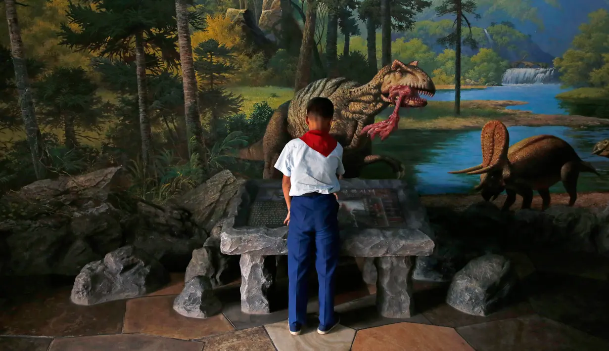 Seorang anak mempelajari informasi dinosaurus di Kebun Binatang di Pyongyang, Korea Utara (15/9). Kebun binatang ini didirikan pada April 1959 atas instruksi Kim Il-sung. (AP Photo/Kin Cheung)