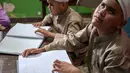 Meskipun bentuknya berbeda dari huruf Arab visual, setiap karakter Braille merupakan kombinasi titik yang melambangkan huruf tertentu. Tampak dalam foto, para siswa tunanetra membaca Al-Quran dalam huruf Braille selama bulan suci Ramadan 1447 Hijriah di sebuah sekolah di Surabaya, Jawa Timur, pada 27 Februari 2026. (JUNI KRISWANTO/AFP)