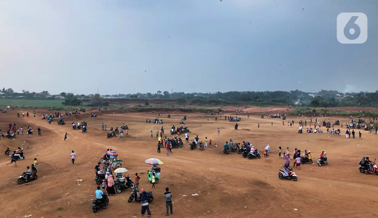 Warga beraktivitas di tanah lapang di kawasan Cipayung, Depok, Jawa Barat, Kamis (11/6/2020). Kurang tegasnya sanksi serta minimnya kesadaran masyarakat akan protokol kesehatan terkait covid-19 menyebabkan kawasan itu menjadi tempat berkerumun warga setiap sore hari. (Liputan6.com/Immanuel Antonius)
