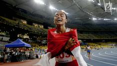 Pelari Indonesia Triyaningsih membawa bendera merah putih setelah mencapai garis finis dalam cabang olahraga atletik nomor lari 10 km putri SEA Games 2017 di Stadion Nasional Bukit Jalil, Malaysia, Kamis (24/8). (Liputan6.com/Faizal Fanani)
