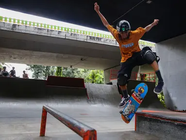 Salah satu remaja saat bermain papan seluncur atau skateboard di taman seluncur (skatepark) dan lintasan sepeda BMX di kolong jalan layang tol dalam kota, Slipi, Jakarta, Selasa (13/5/2025). (Liputan6.com/Angga Yuniar)