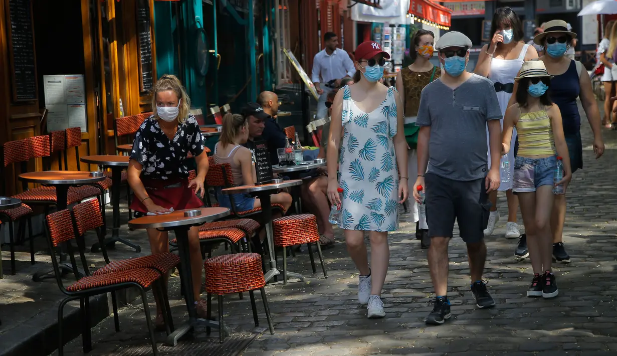 Turis berjalan-jalan di distrik Montmartre, Paris pada Senin (10/8/2020). Pemerintah Kota Paris mengumumkan masker wajib dipakai di area luar ruangan yang ramai di ibu kota Prancis itu mulai Senin (10/8) untuk mengendalikan peningkatan tingkat infeksi virus corona. (AP Photo/Michel Euler)