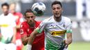 Pemain Borussia Moenchengladbach, Ramy Bensebaini, berebut bola dengan pemain Union Berlin, Marcus Ingvartsen, pada laga Bundesliga di Stadion Borussia-Park, Minggu (31/5/2020). Moenchengladbach menang 4-1 atas Union Berlin. (AP/Martin Meissner)