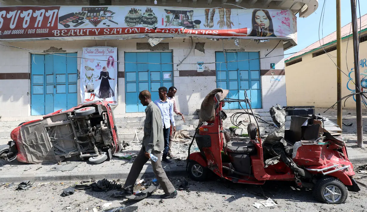 Sejumlah warga mengecek bajaj yang rusak parah usai terkena ledakan bom yang terjadi di Ibu Kota Mogadishu, Somalia (28/3). Hingga kini, belum ada pihak yang bertanggung jawab atas serangan ini. Namun, muncul dugaan kelompok militan berada di balik aksi tersebut. (Reuters/Feisal Omar)