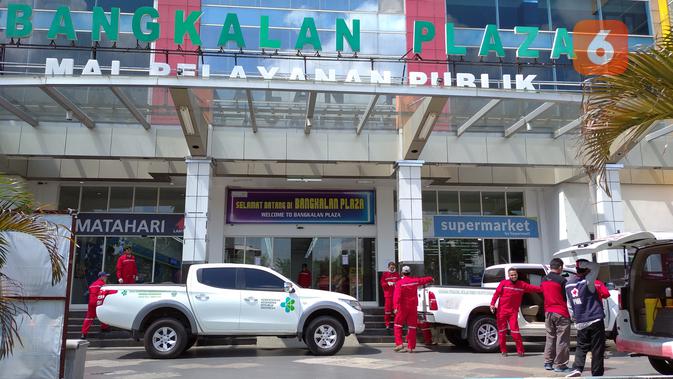 Satgas Covid 19 Bangkalan menyemprotkan cairan disinfektan di sebuah tempat pusat perbelanjaan